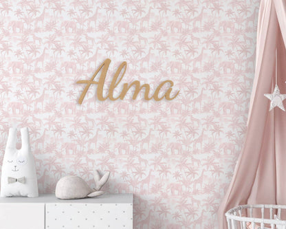 Decorative wall with floral pattern, 'Alma' nameplate, and baby items against a pink background