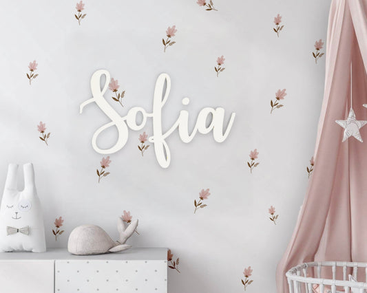 Children's room with floral wall decals, a name sign, and decorative elements.