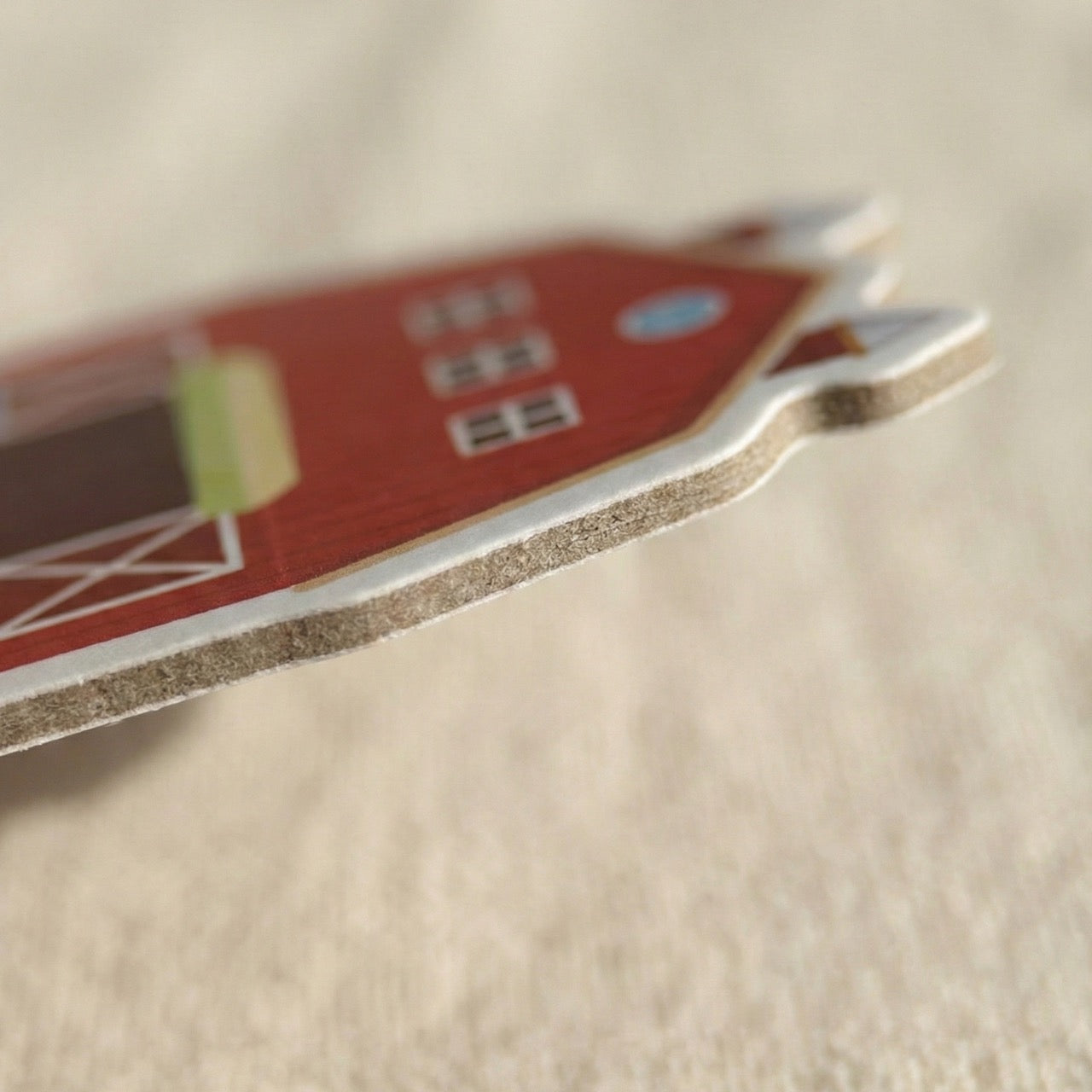 Close-up side view showing the thick, safe foam layer of a red barn magnet.