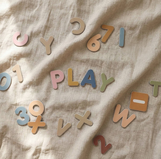 Open ended Montessori play with magnetic letters and numbers on natural fabric background